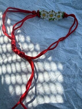 Three Flower Petals With A Red String Bracelet